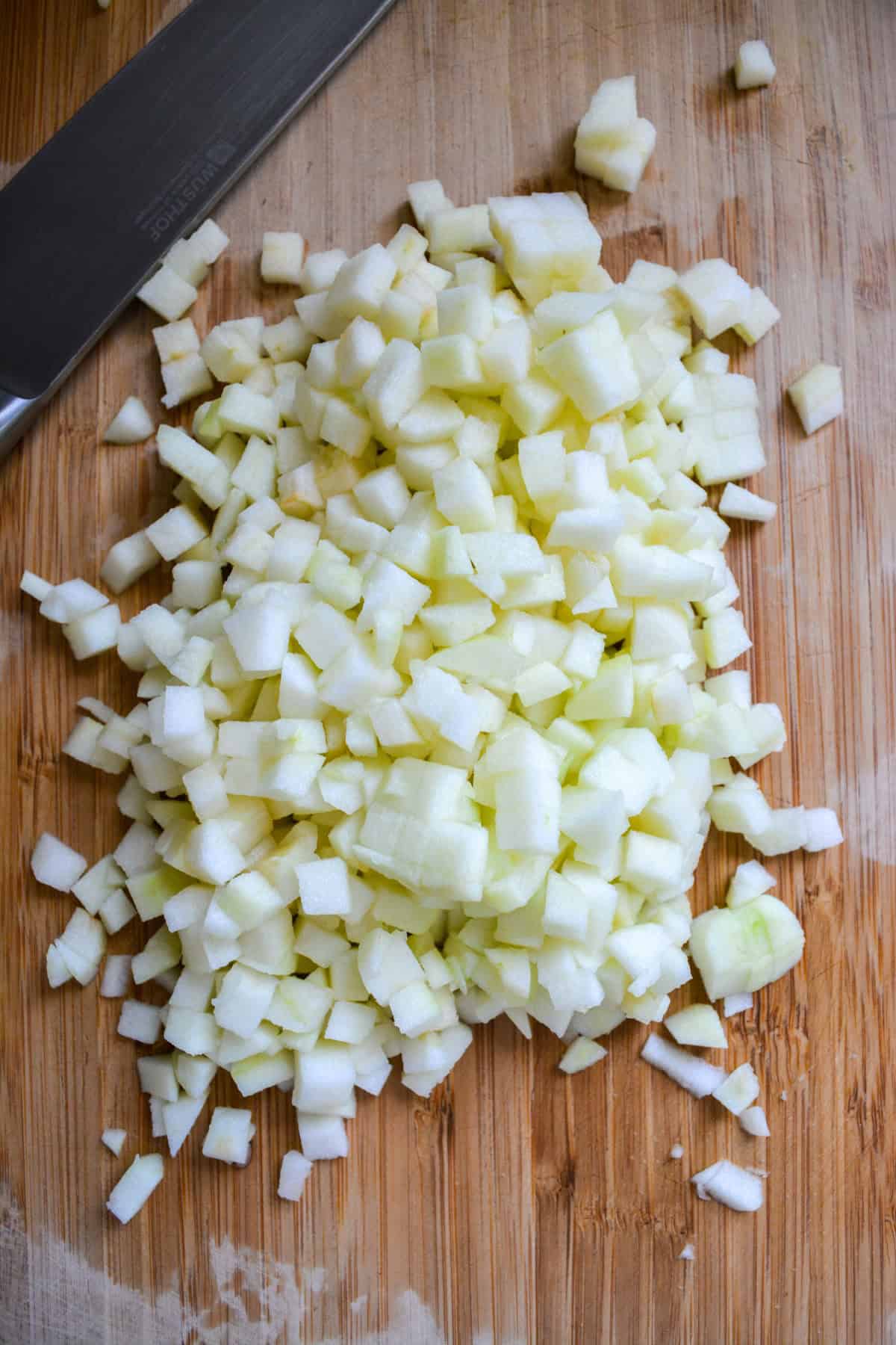 Chopped apple on a wooden cutting board.