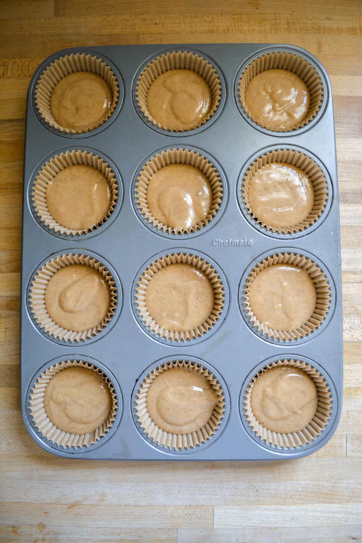 Cupcake batter scooped into a lined cupcake pan.