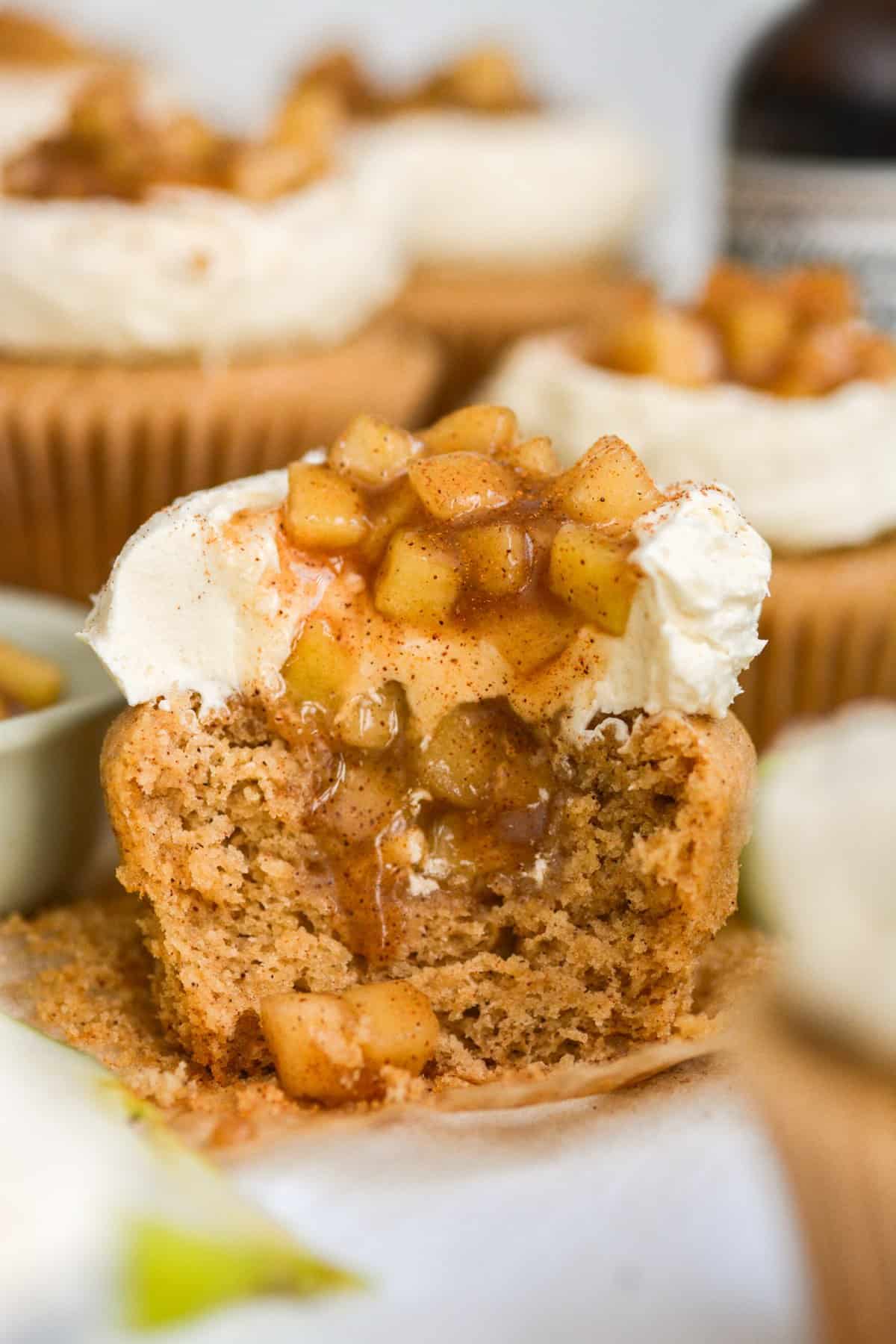 Spiced Apple Pie Cupcake with a bite taken out of it on a cupcake liner.