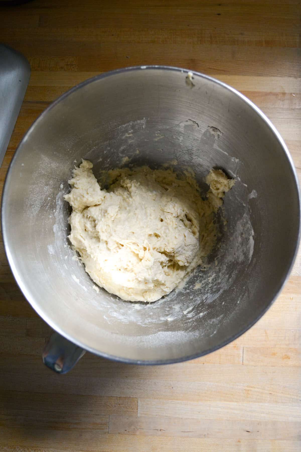 Shaggy dough in a metal mixing bowl.