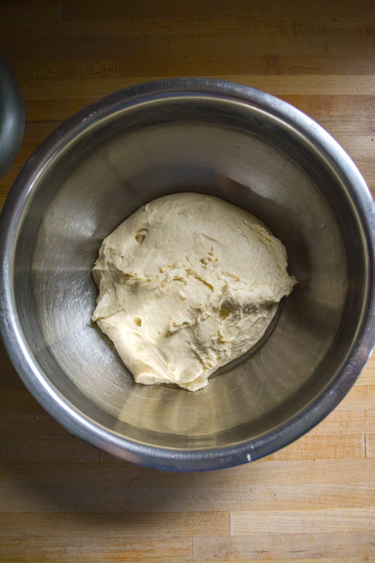 Kneaded dough in a mixing bowl ready to proof.