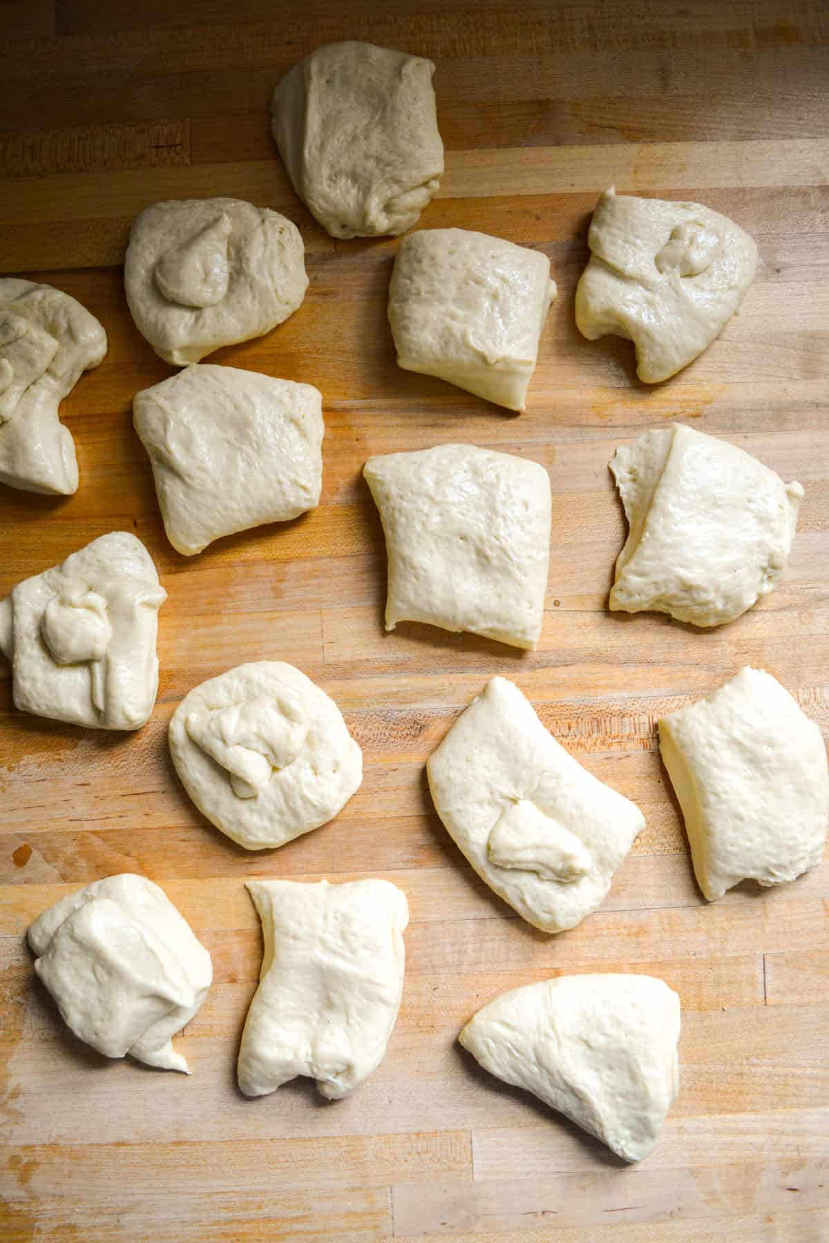 Dough portioned out on a wooden surface.