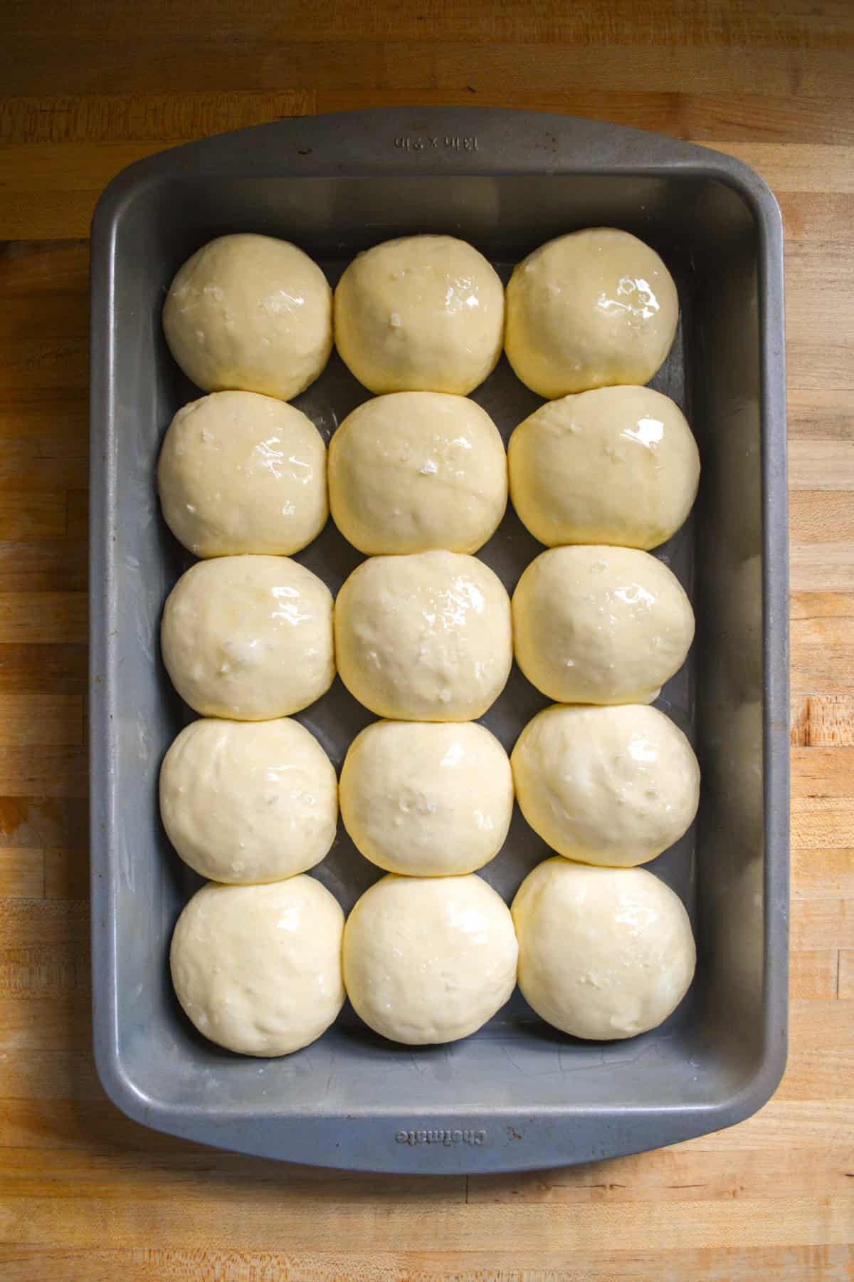 Risen dinner roll dough balls ready for the oven.