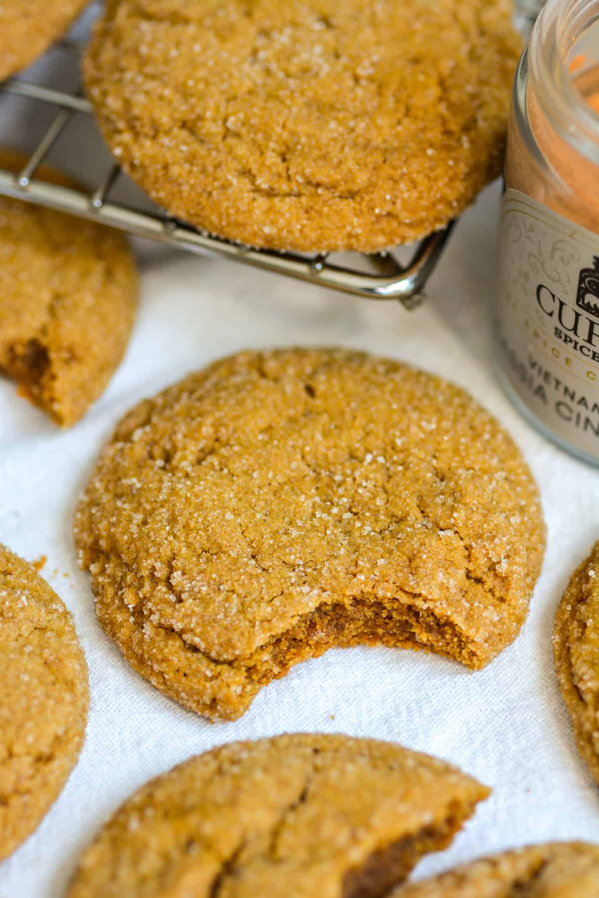 A Chewy Vegan Molasses Ginger Cookie with a bite taken out of it.