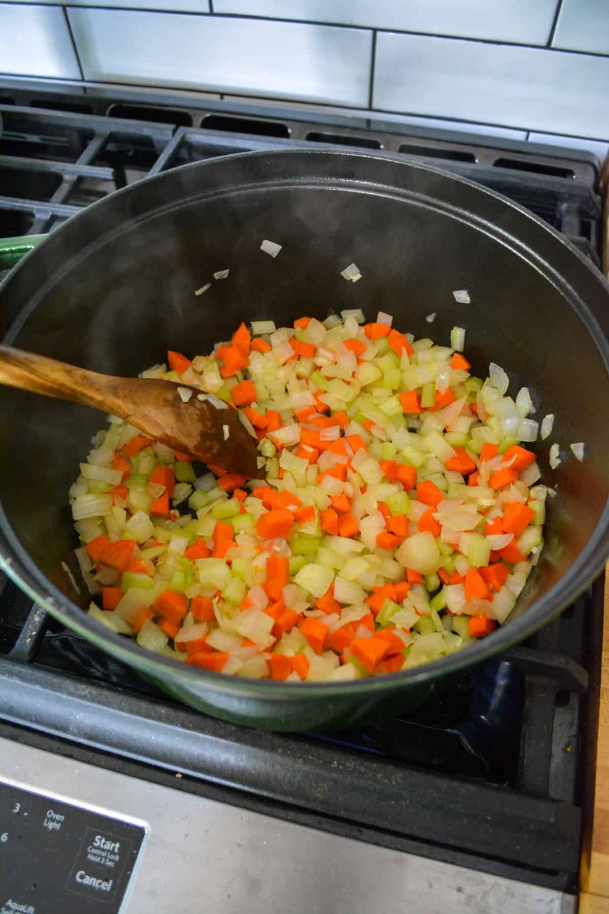 Onions, carrots and celery cooking in a large Dutch oven.