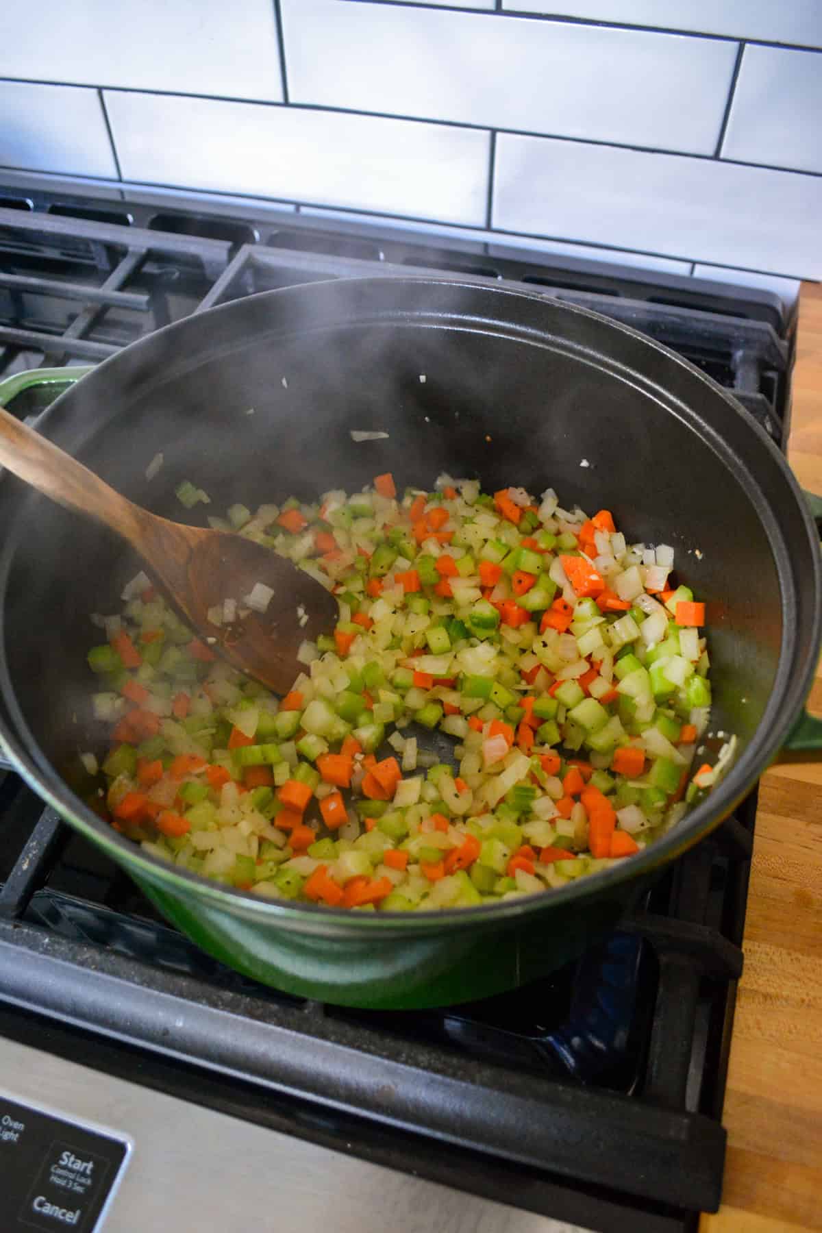 Sautรฉing vegetables in a large Dutch oven.