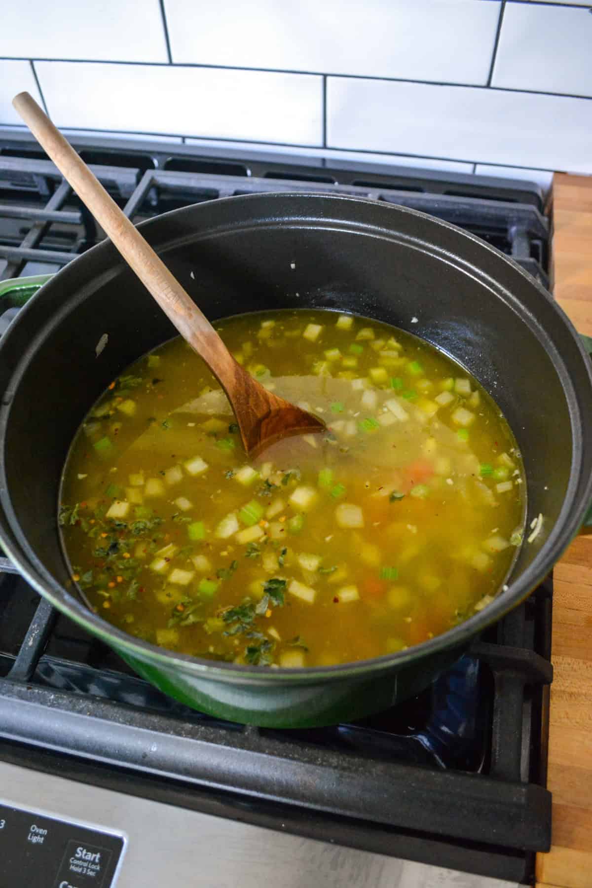 Broth, chickpeas and herbs added into the Dutch oven.