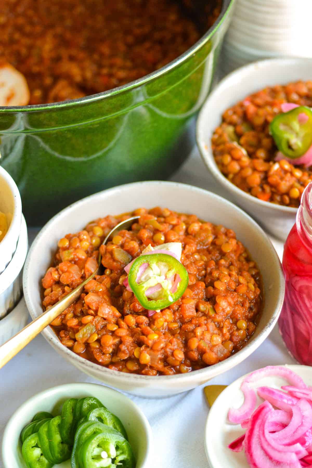 Two bowls of lentil chili on a linen cloth.