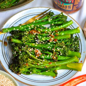A small plate with stir fried broccolini on it.