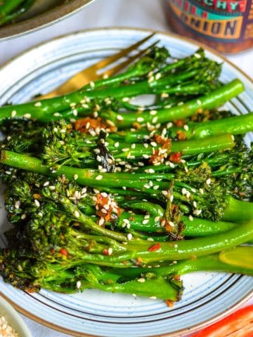 A small plate with stir fried broccolini on it.