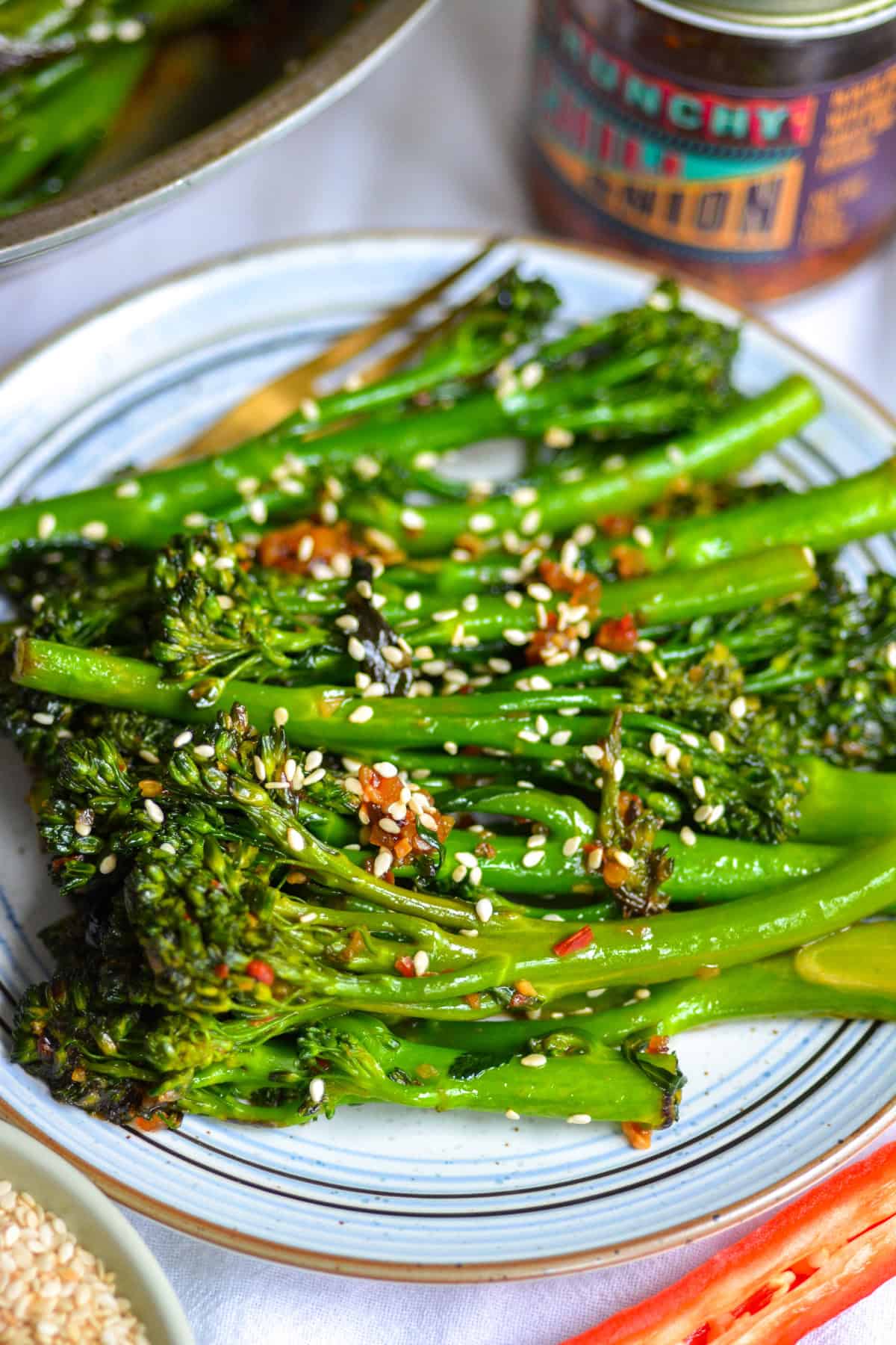 A plate with Stir Fried Broccolini topped with sesame seeds on it.