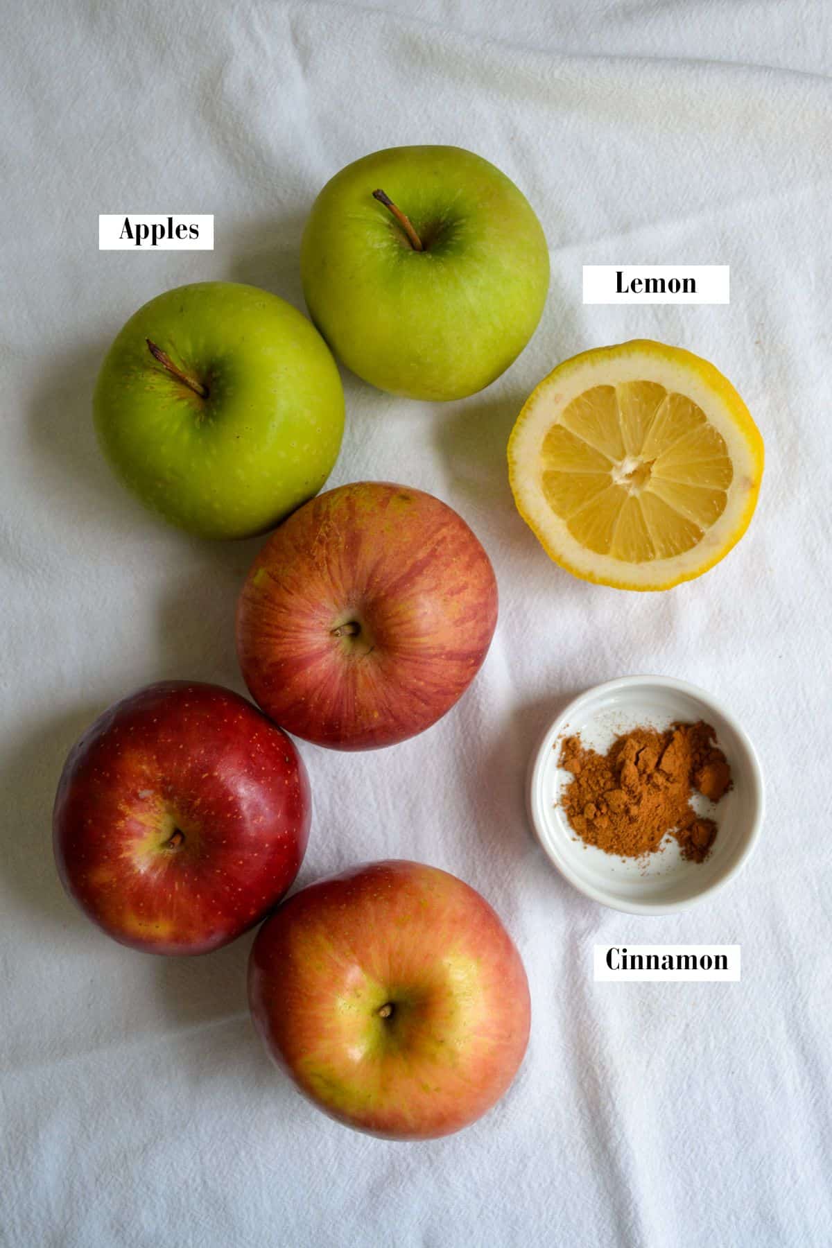 Apples, cinnamon and lemon on a linen cloth.
