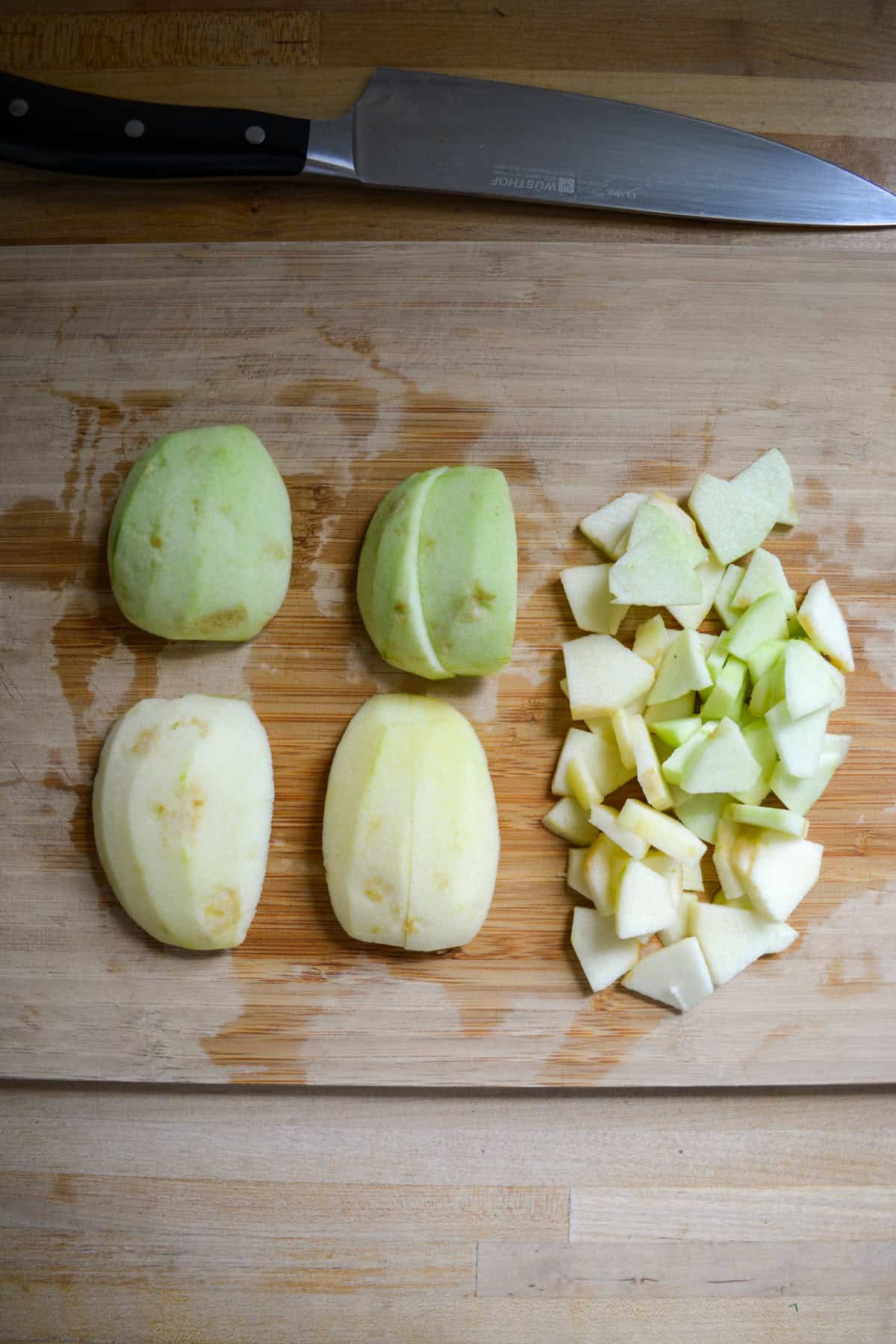 Stages of cutting apples on a wooden cutting board.