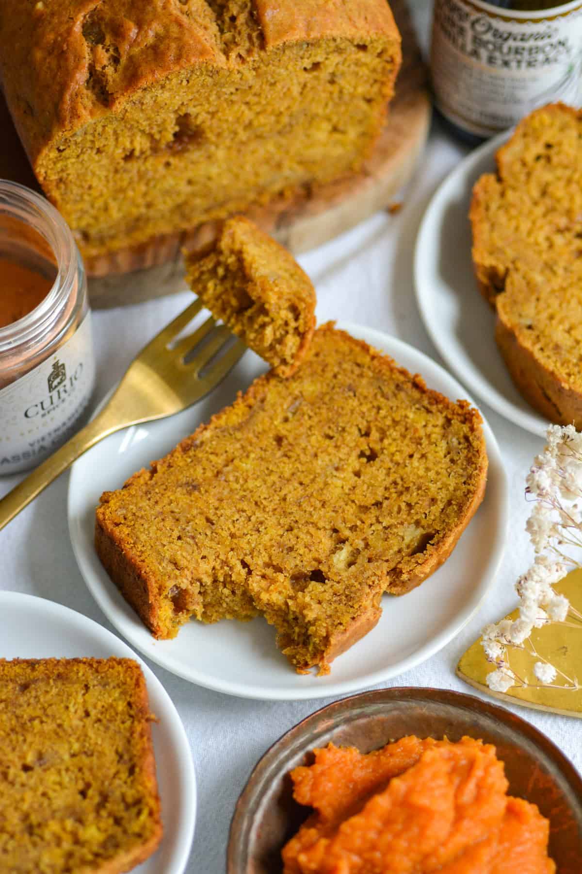 Slices of Vegan Banana Pumpkin Bread on small plates on a linen cloth.