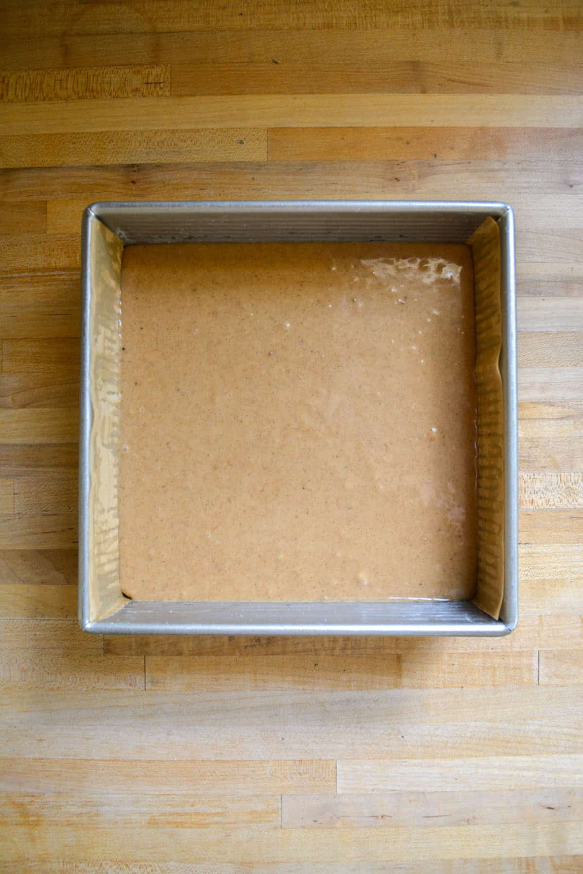 Cake batter in a square baking pan.