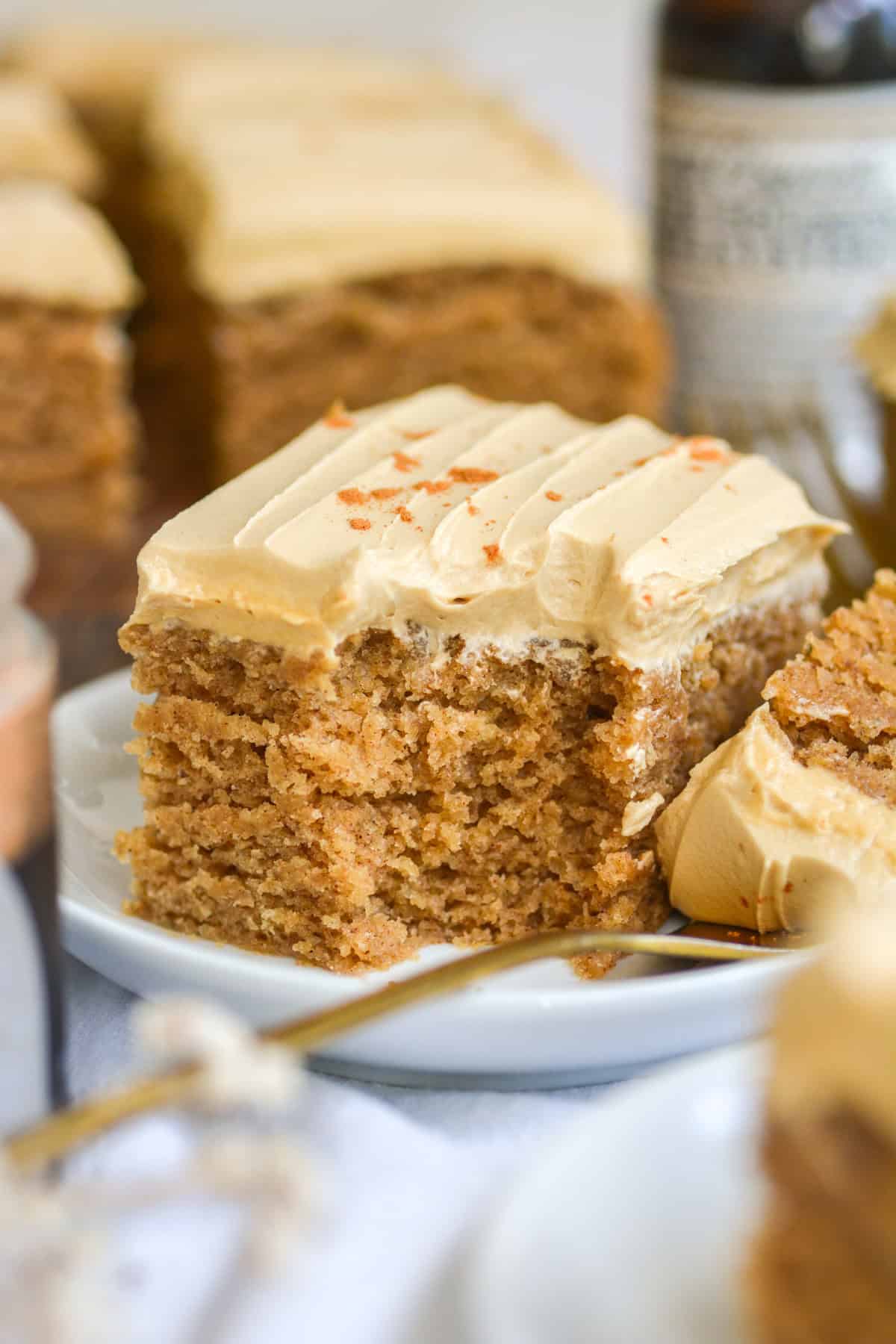 A slice of Vegan Dirty Chai Cake on a plate with a bite taken out of it.