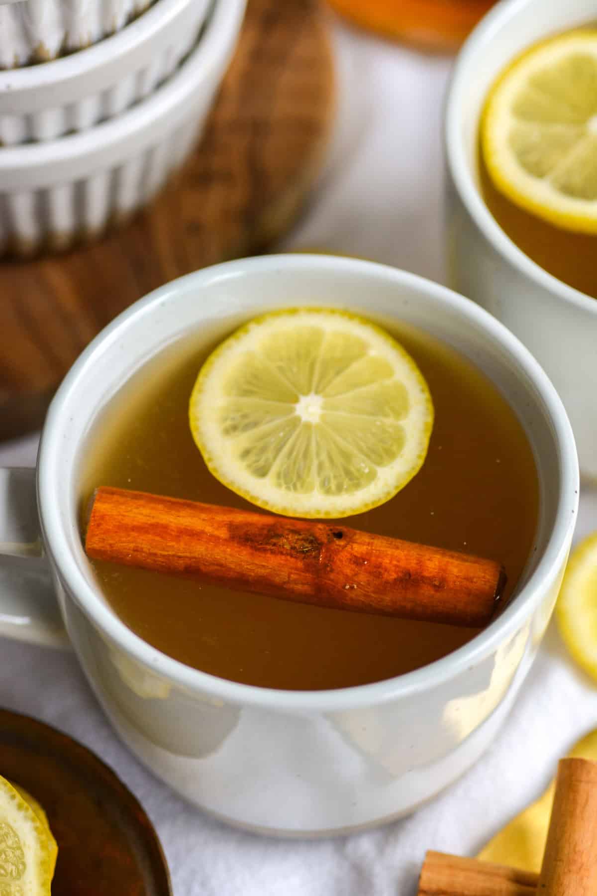 Bourbon hot toddy in a mug topped with a lemon wheel.