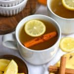 A bourbon hot Toddy in a white mug on a linen cloth.