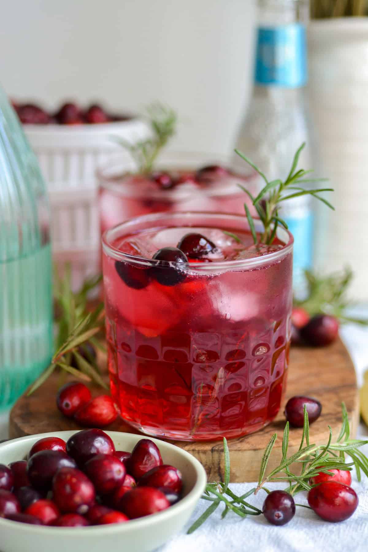 Cranberry Gin Cocktail in a rocks glass on a small wooden board.