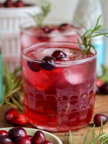 Cranberry Gin Cocktail in a glass garnished with a sprig of rosemary.