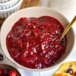 Orange Cranberry Sauce in a bowl with a gold spoon.