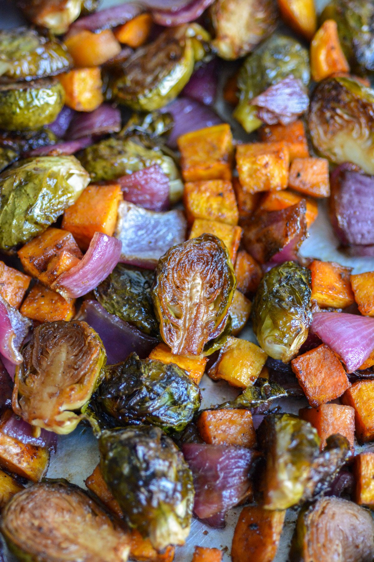 Roasted Brussels Sprouts and Sweet Potatoes on a baking sheet.