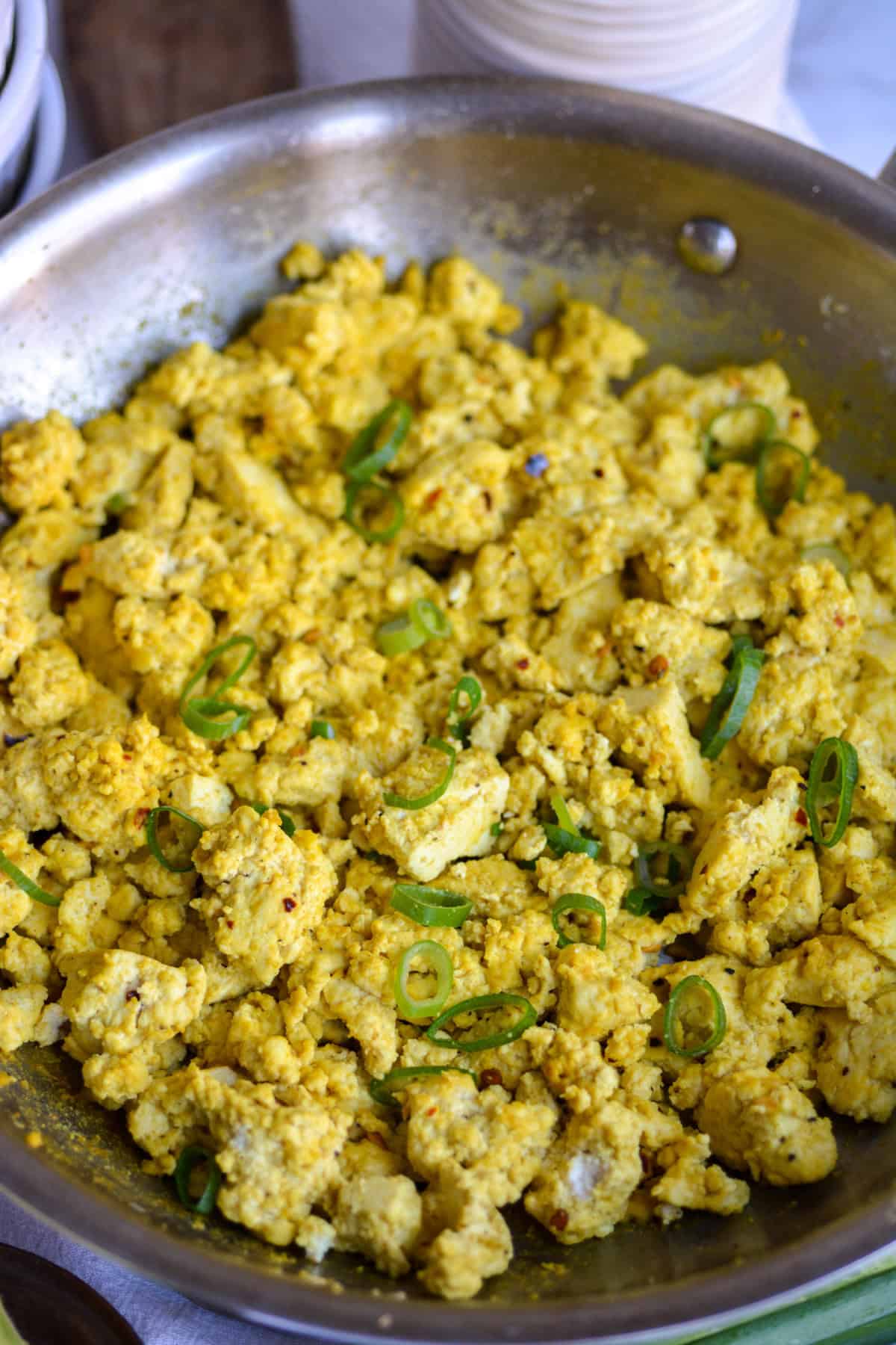 Vegan Tofu Scramble in a skillet topped with green onion.