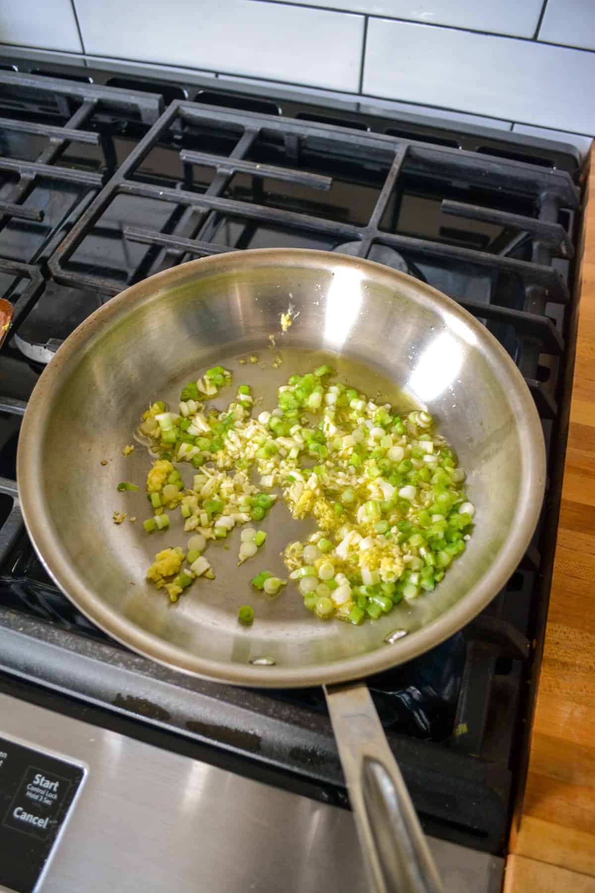 Garlic, ginger and green onion in a skillet.