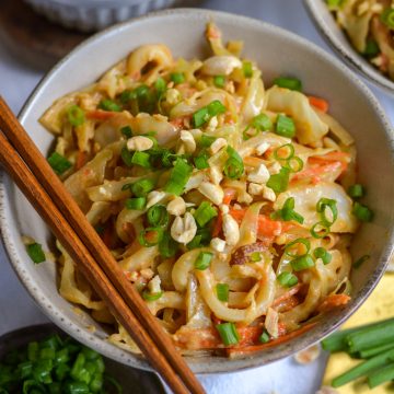 Vegan Peanut Udon Noodles in a bowl with chopsticks.