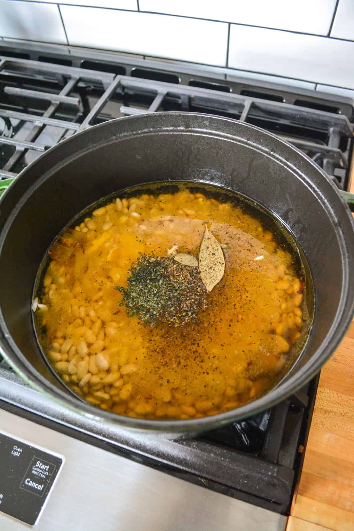 Beans, water and herbs added into the pot.