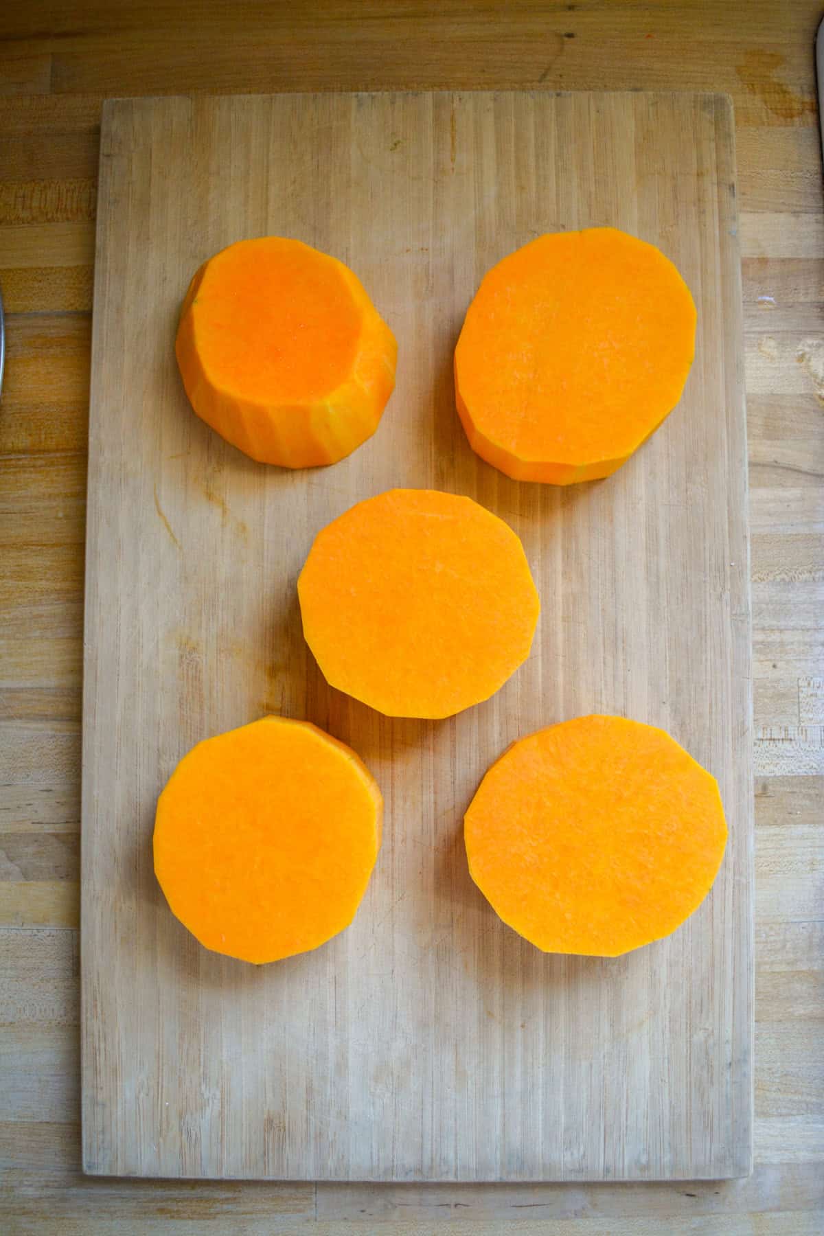 Butternut Squash steaks on a cutting board.