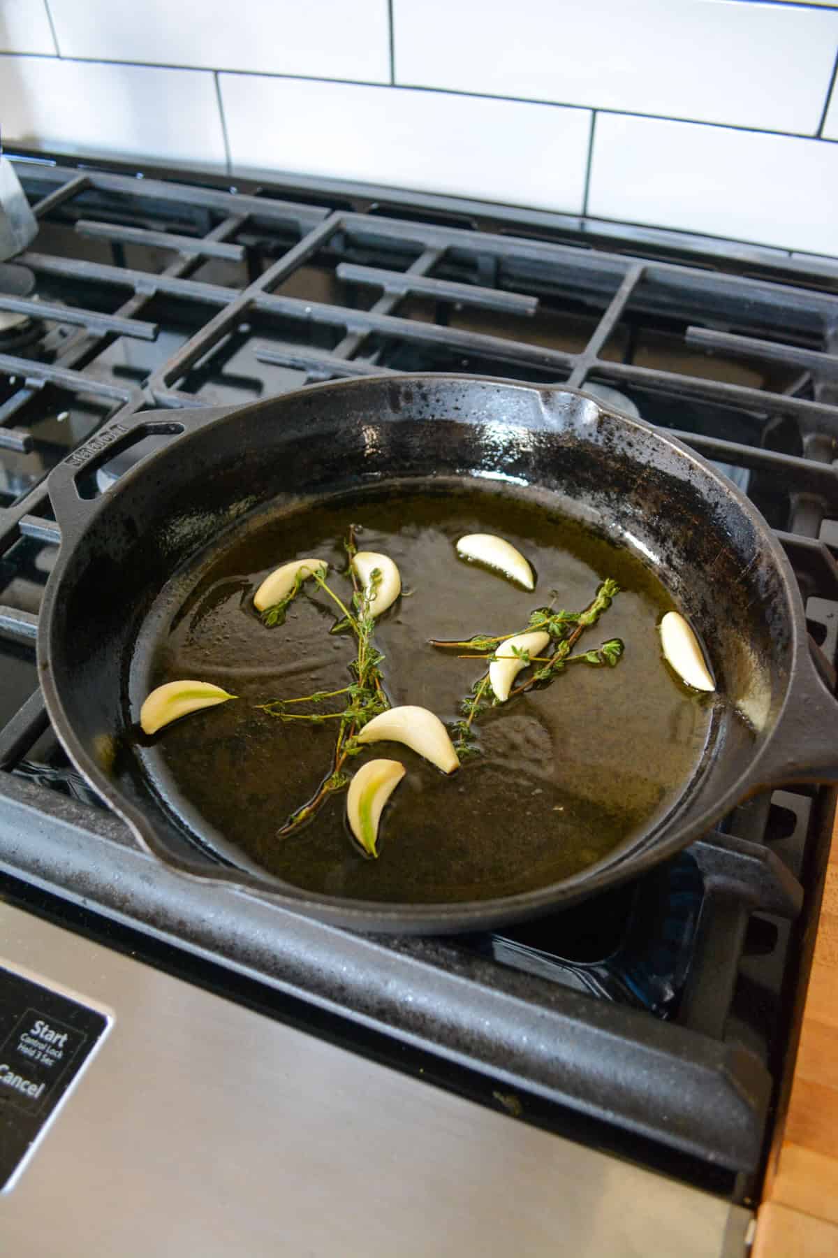 Olive oil, garlic and thyme in a skillet.
