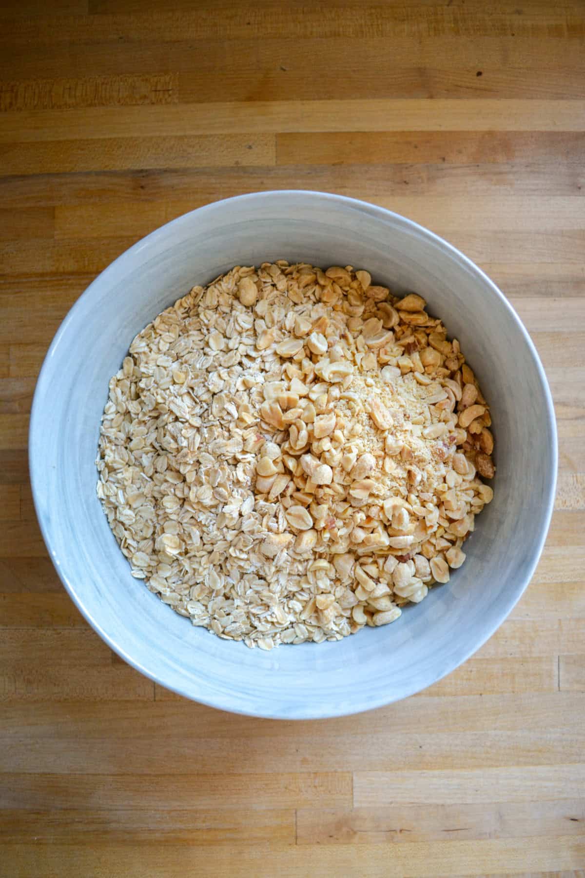 Rolled oats and chopped nuts in a large mixing bowl.