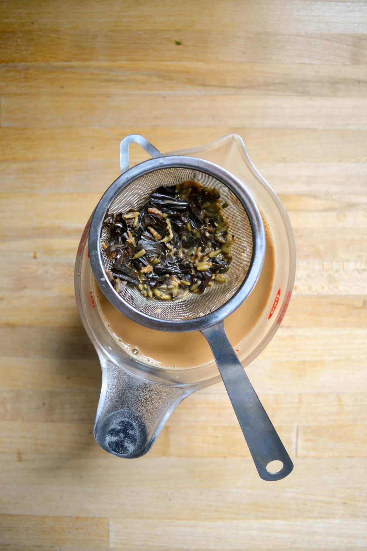 Straining the tea out of the liquid.