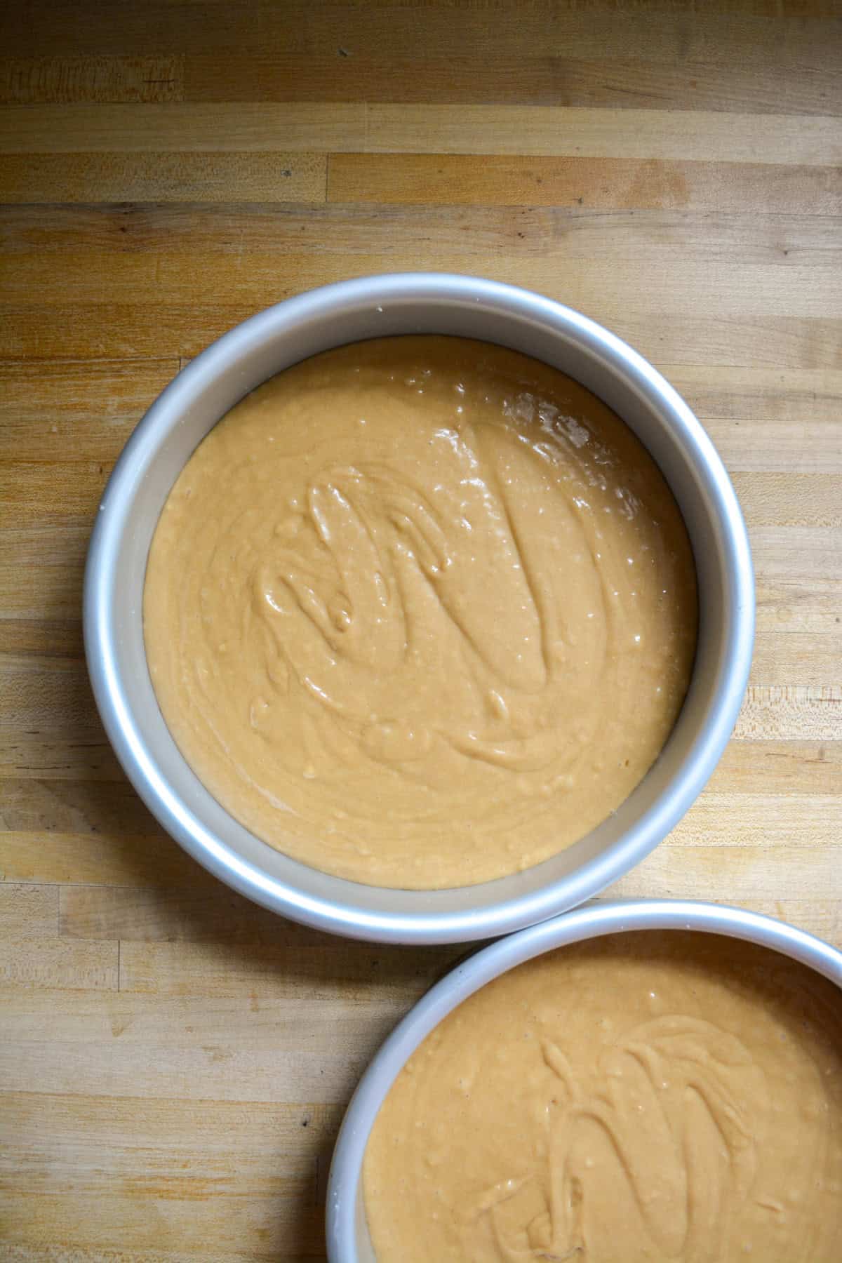 Cake batter in two round cake pans.