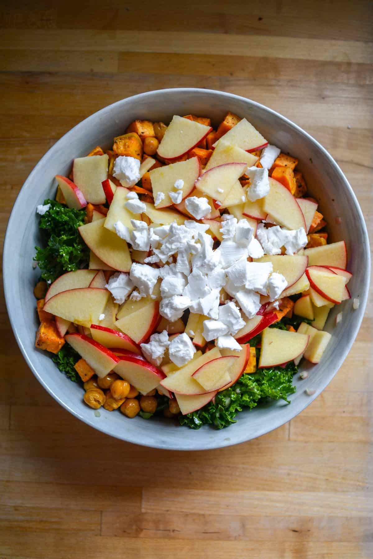 Kale topped with roasted sweet potato, chickpeas, sliced apples and feta cheese.