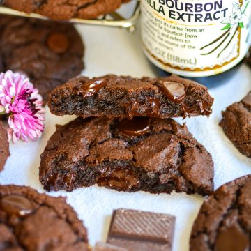 A Vegan Chocolate Chocolate Chip Cookies that is broken in half on a linen cloth.
