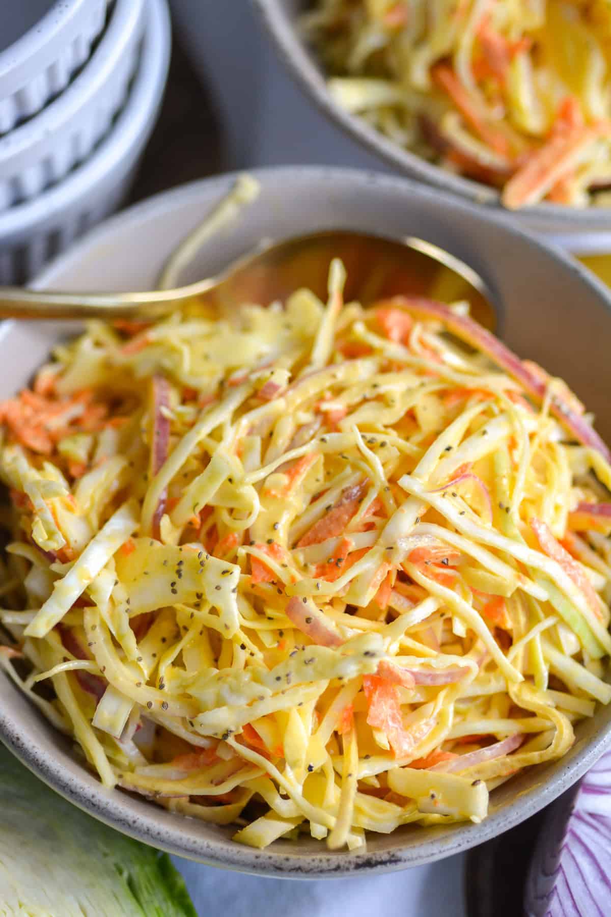 Vegan Coleslaw in a bowl with a gold spoon.