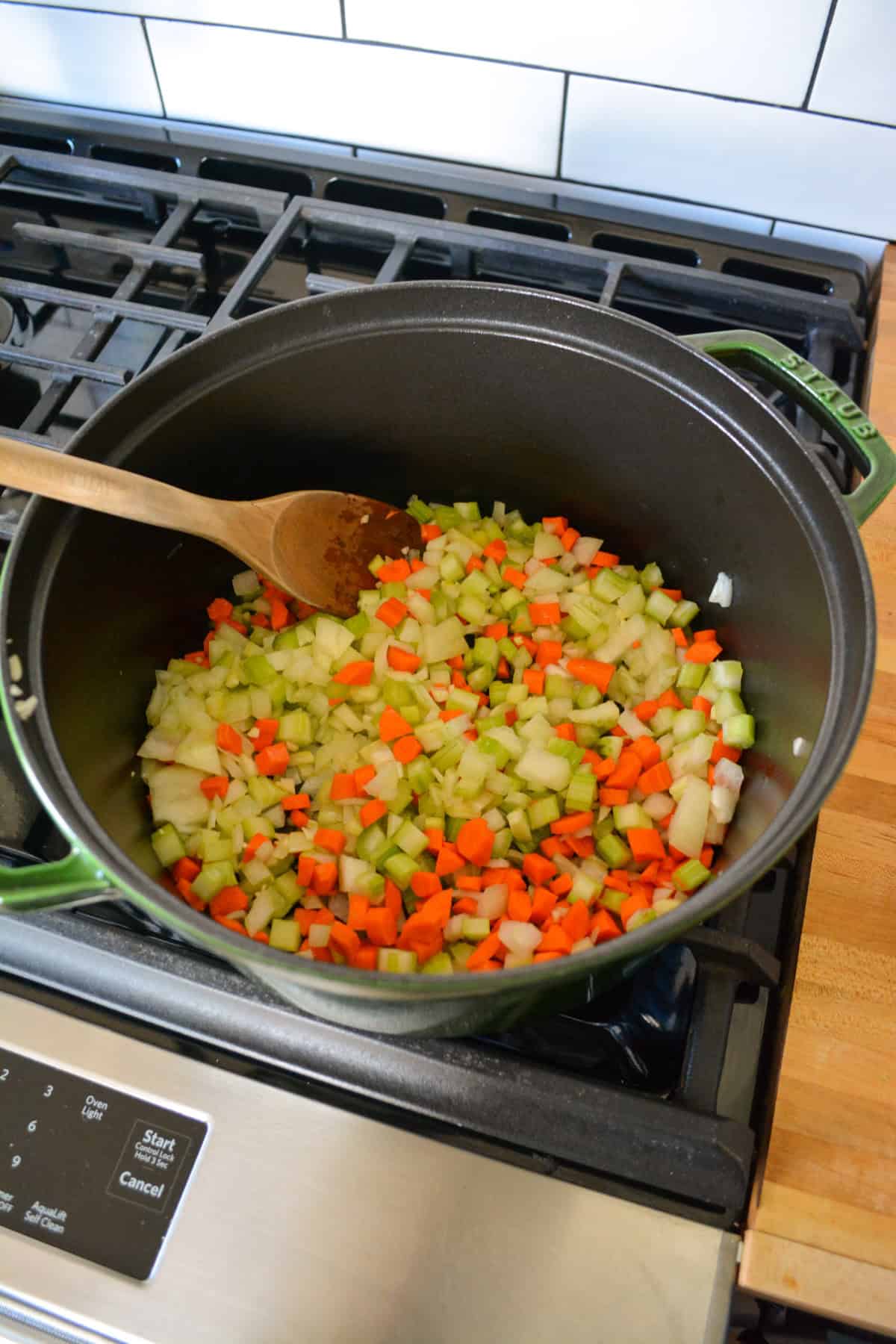 Onion, celery and carrots cooking in a large Dutch-oven.