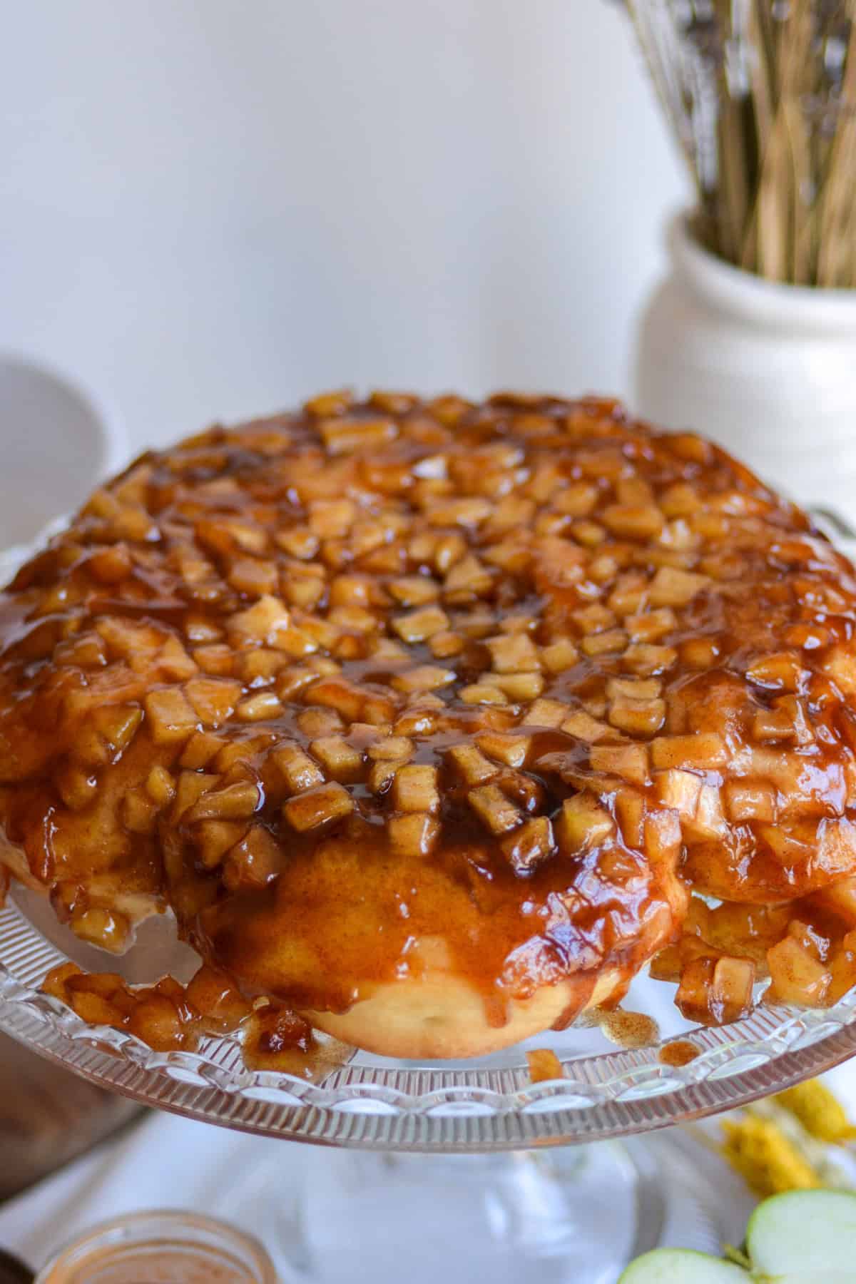 Apple Pie Cinnamon Rolls flipped upside down onto a cake stand.
