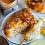 Apple Pie Cinnamon Roll on a plate with a bite taken out of it.