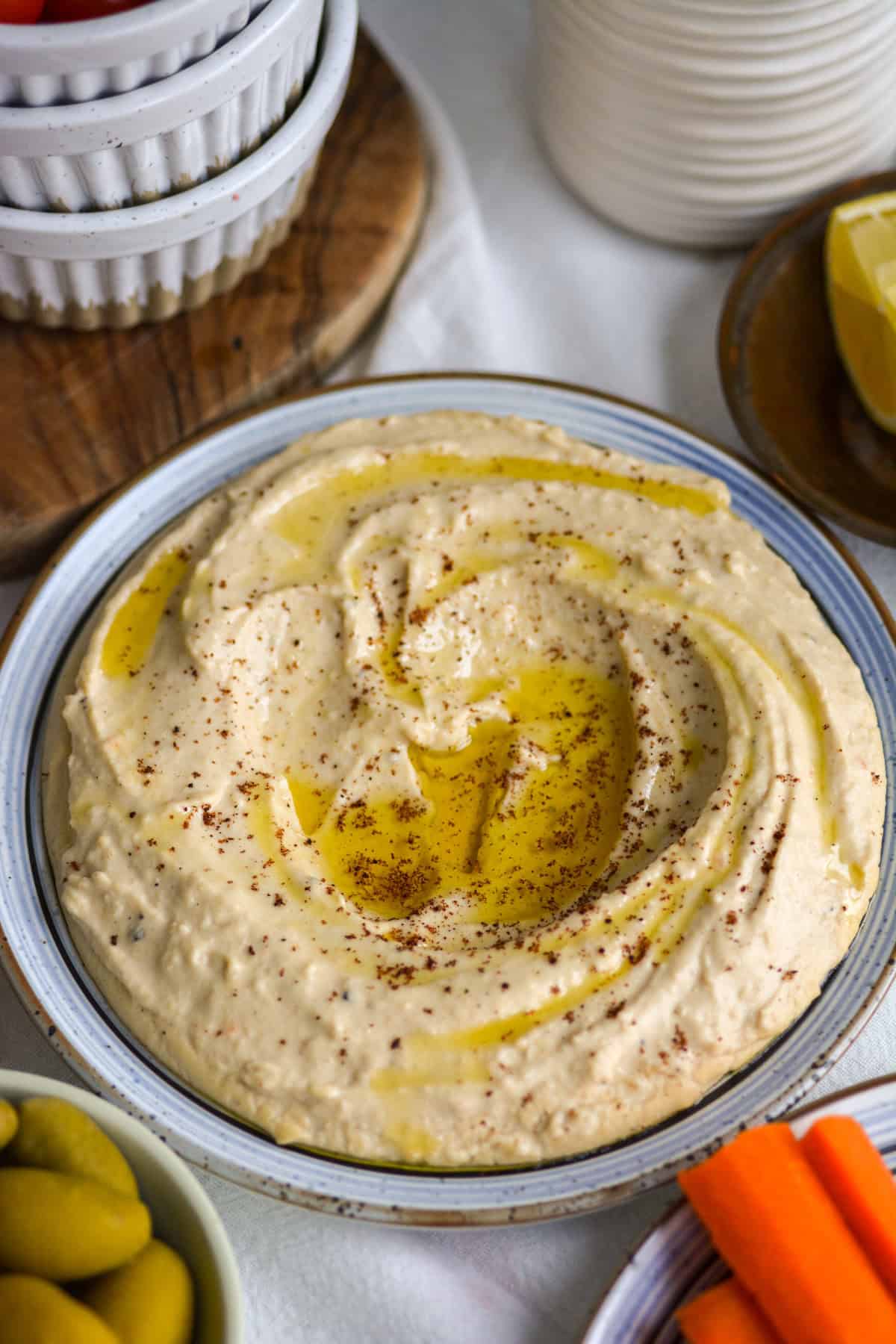 Red Lentil Hummus topped with olive oil and sumac on a plate.