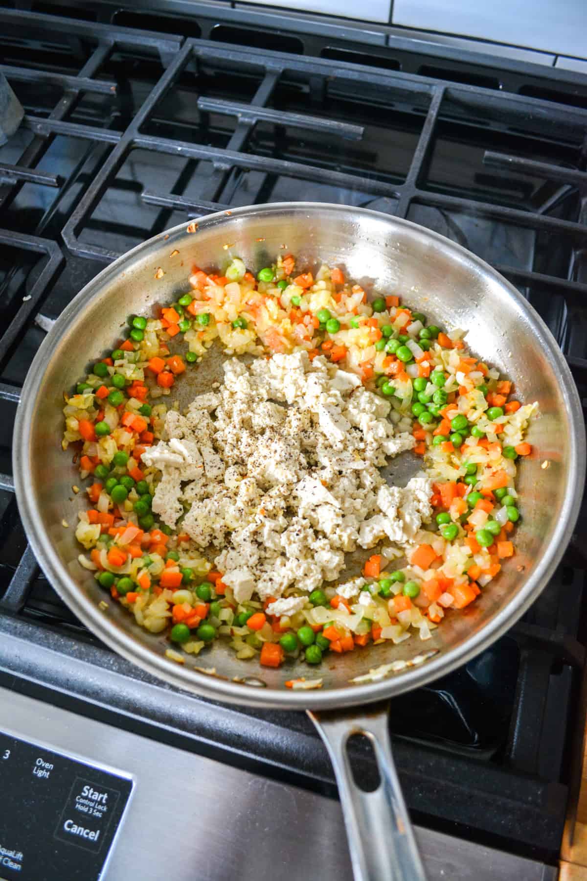 Crumbled tofu added to the center of the skillet.