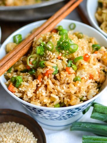 Vegan Fried Rice in a small bowl with chopsticks on top.