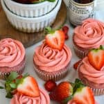 Vegan Strawberry Cupcakes on a linen cloth topped with a fresh strawberry.
