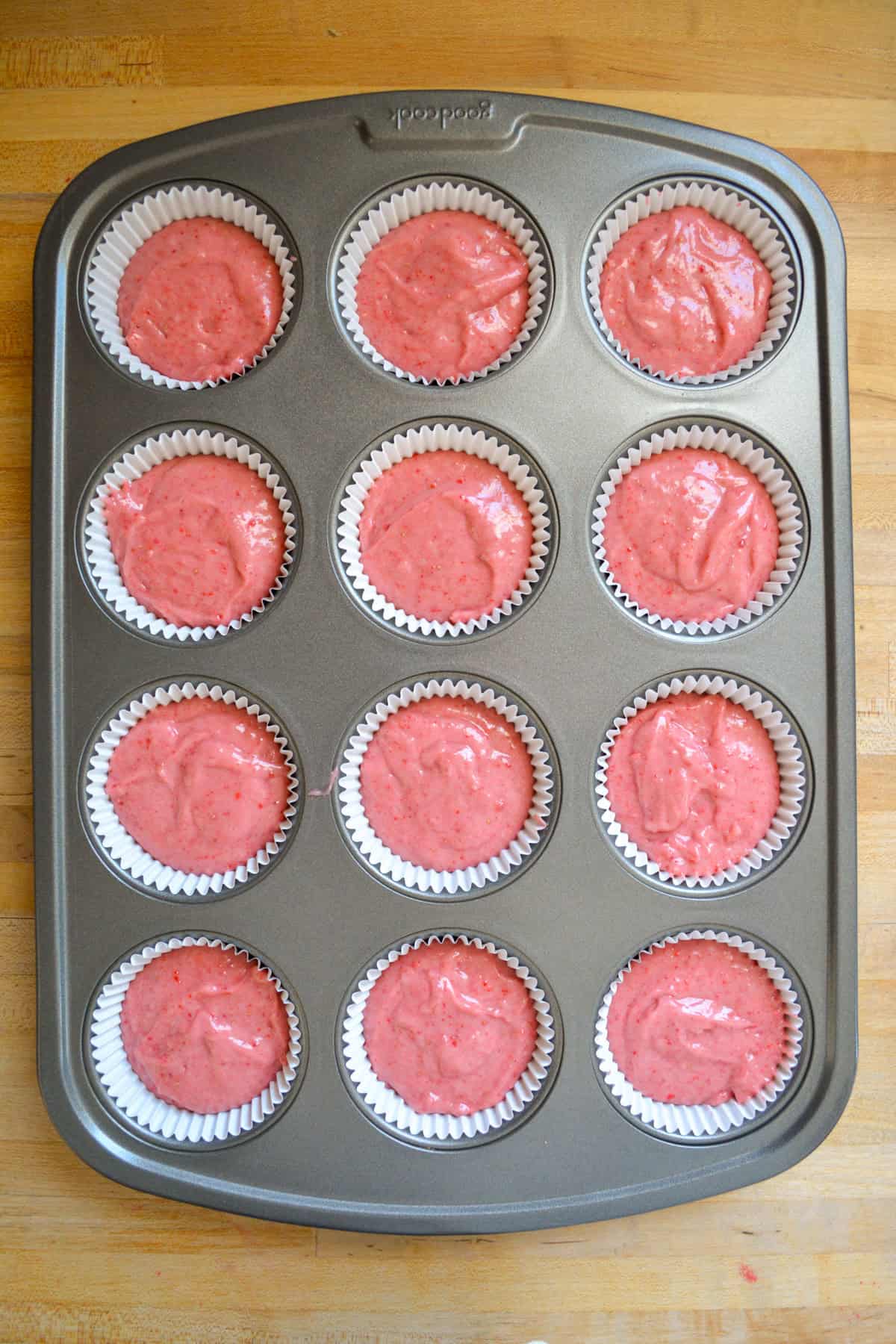 Cupcake batter in a lined cupcake tin ready to bake.