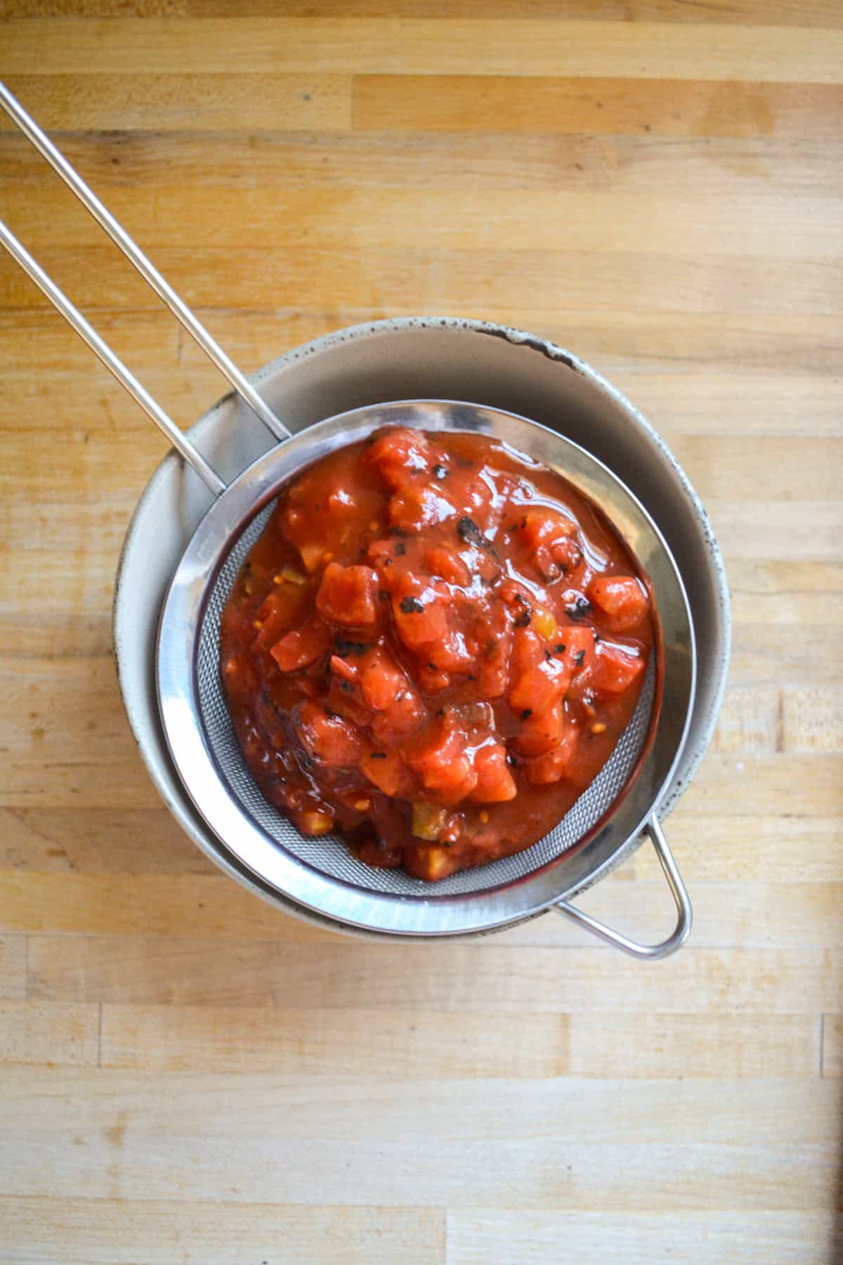 Diced tomatoes in a strainer.