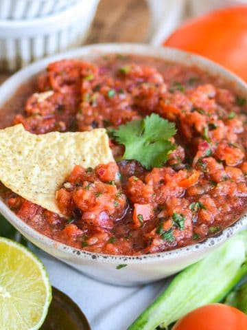 Homemade Vitamix Blender Salsa in a bowl with a tortilla chip in it.
