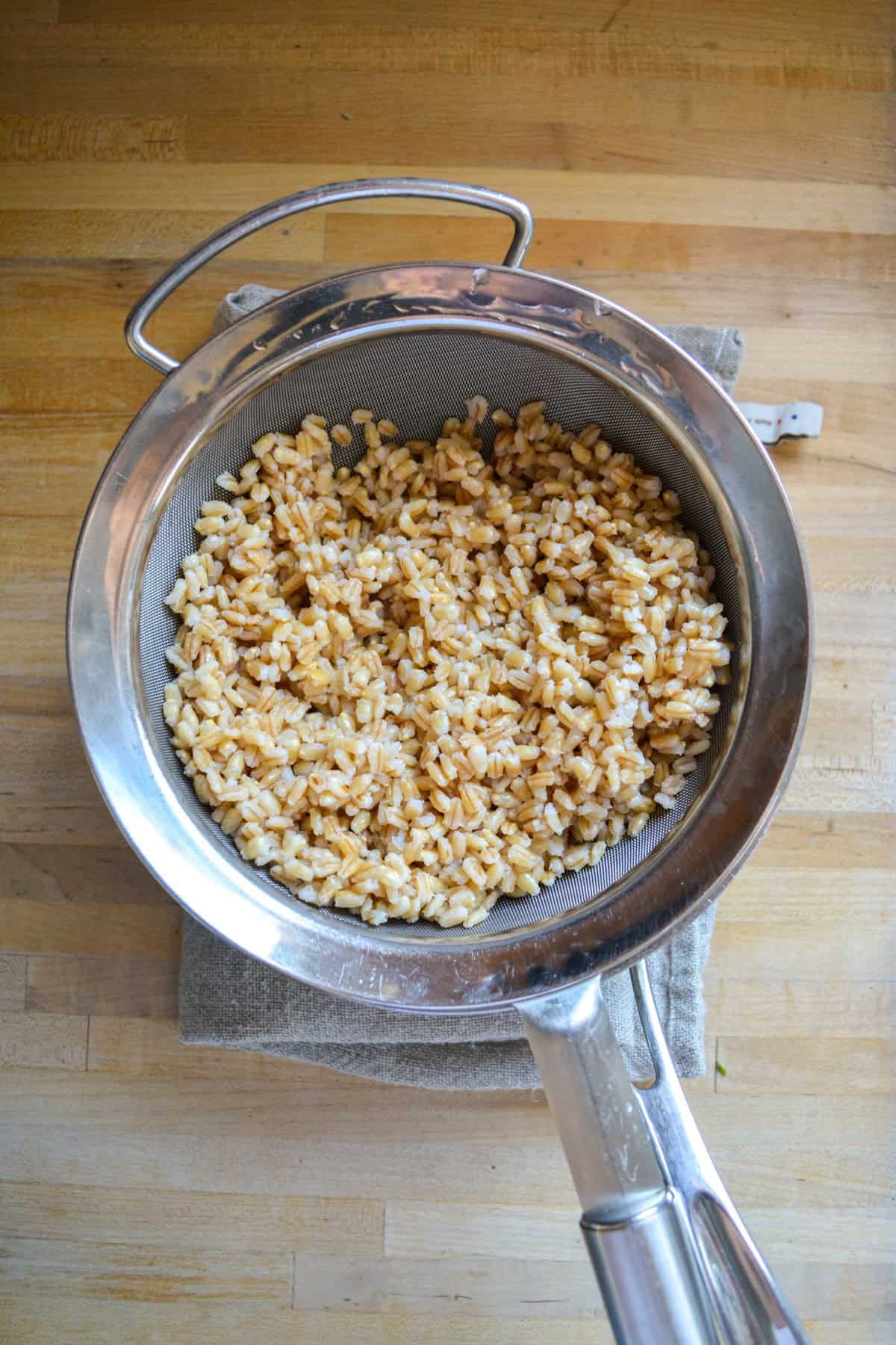 Cooked barley in a strainer.