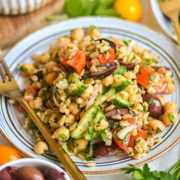 Barley salad with chickpeas, cucumbers and tomatoes on a plate.